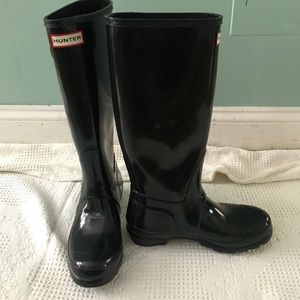 Tall glossy black hunter boots with shiner